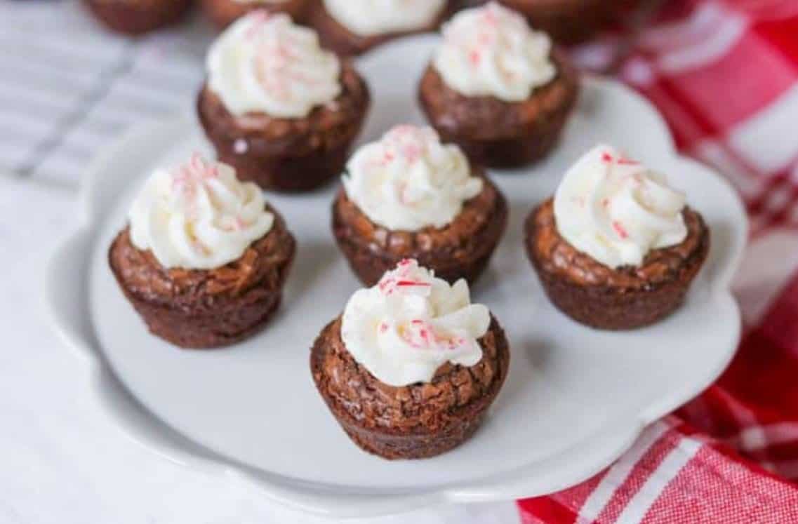 Brownie bites on a cake plate with checkered cloth.