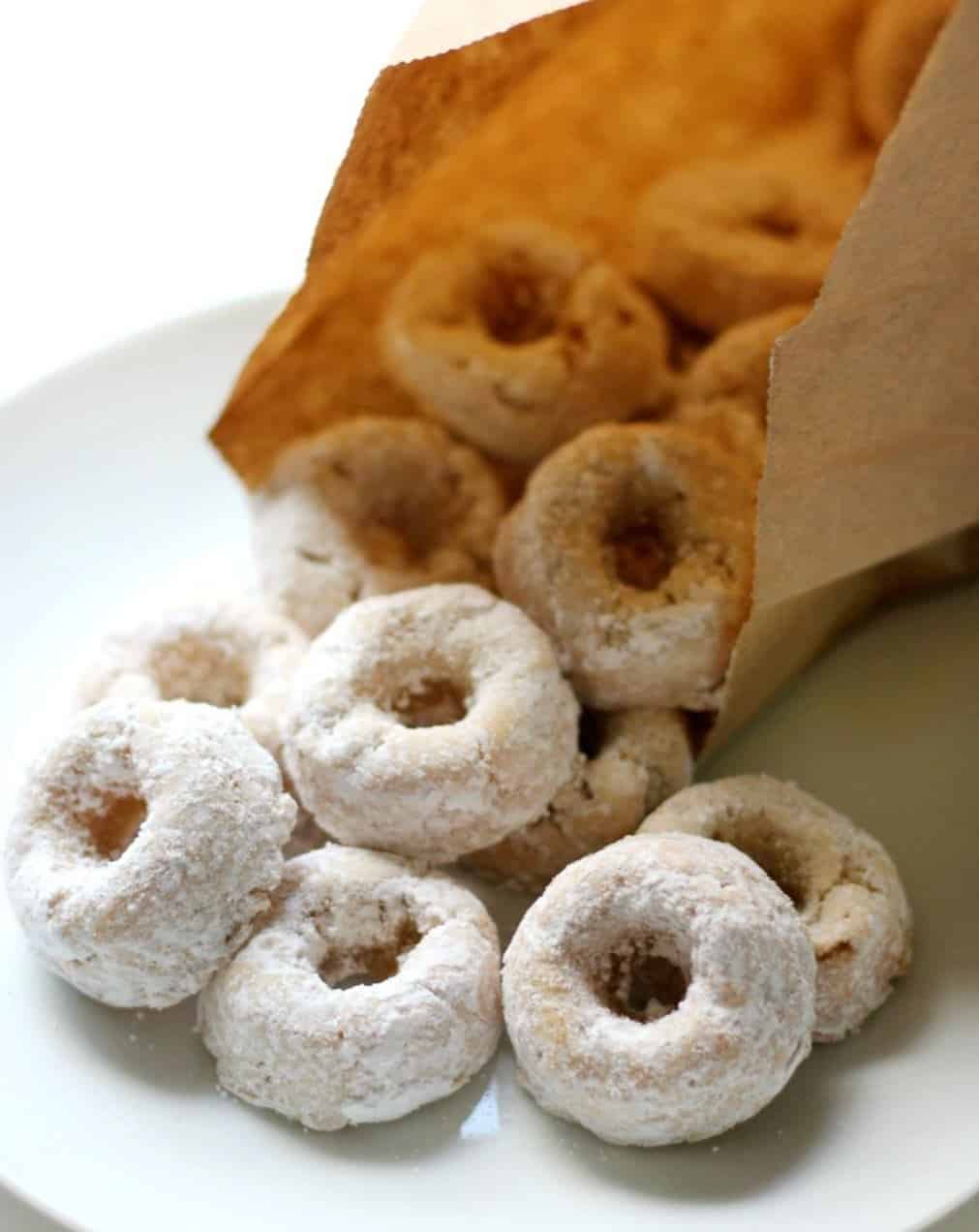 Mini donuts being poured out of a paper bag. 