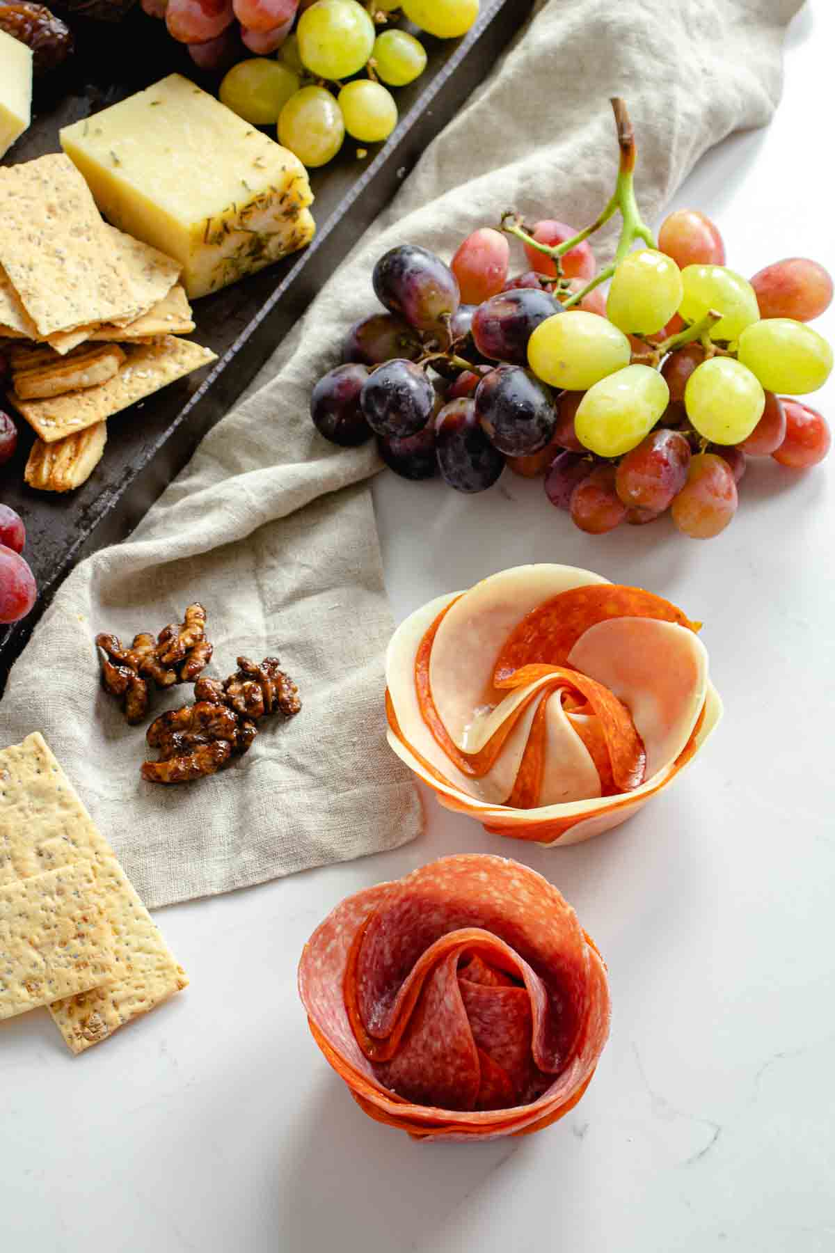 Pepperoni, salami and cheese rose flowers on charcuterie board.