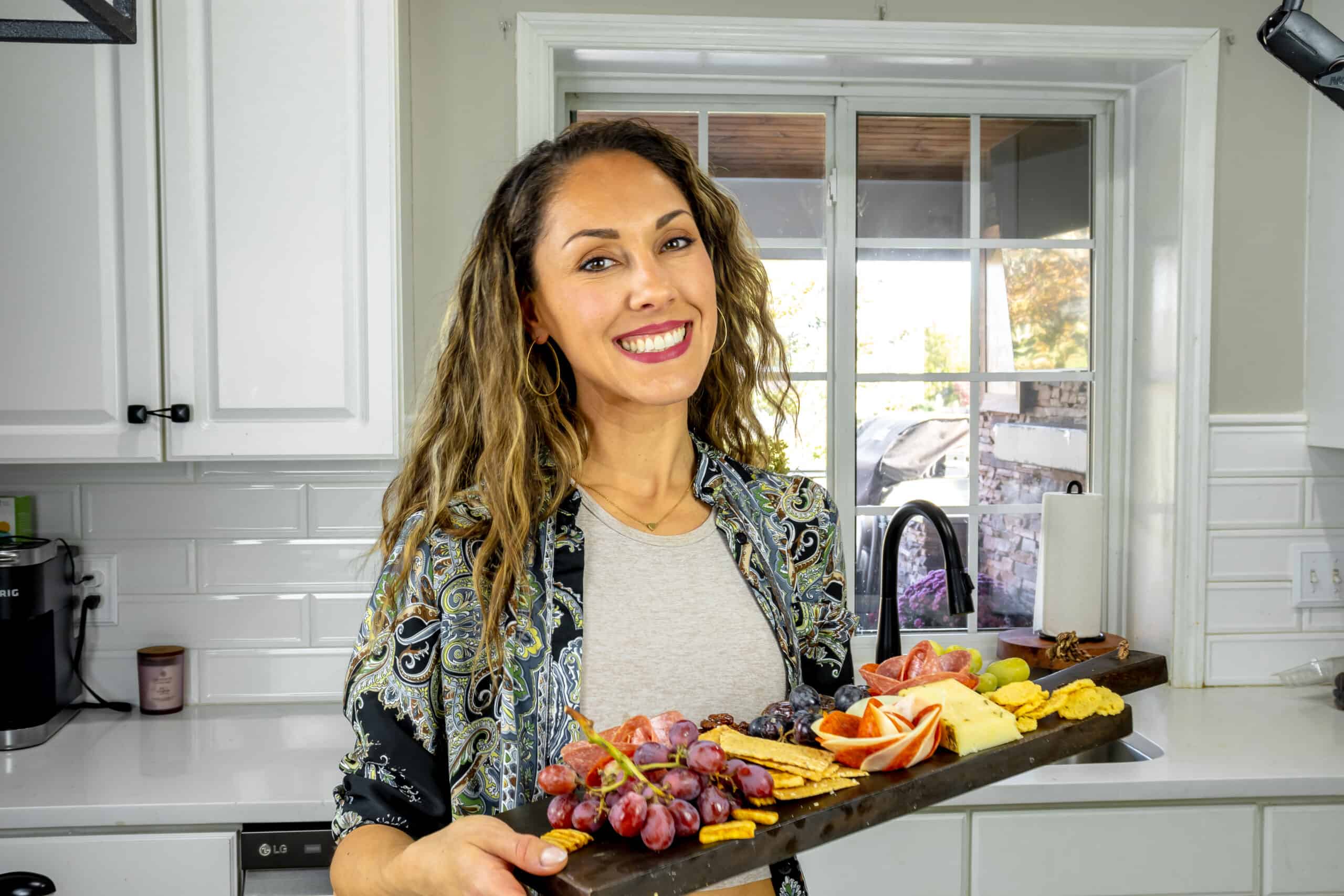 Aleka holding charcuterie board with meat roses.