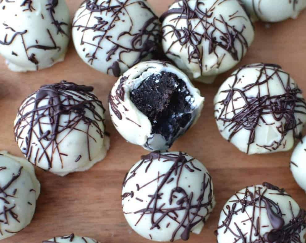 Oreo truffle balls on a wooden cutting board. 