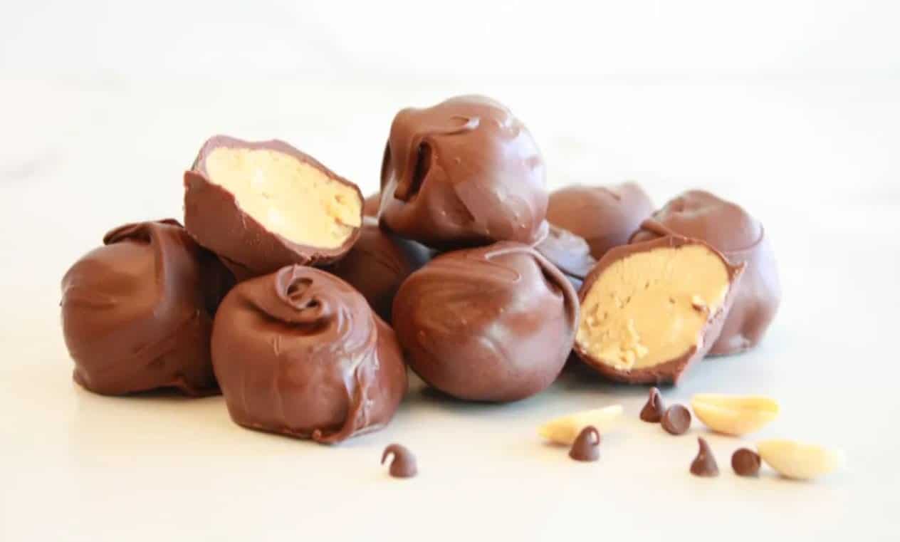 Peanut butter balls covered in chocolate with peanuts and chocolate chips. 