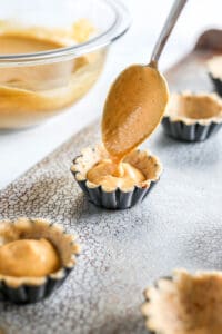 Dough with pumpkin filling in muffin tin.