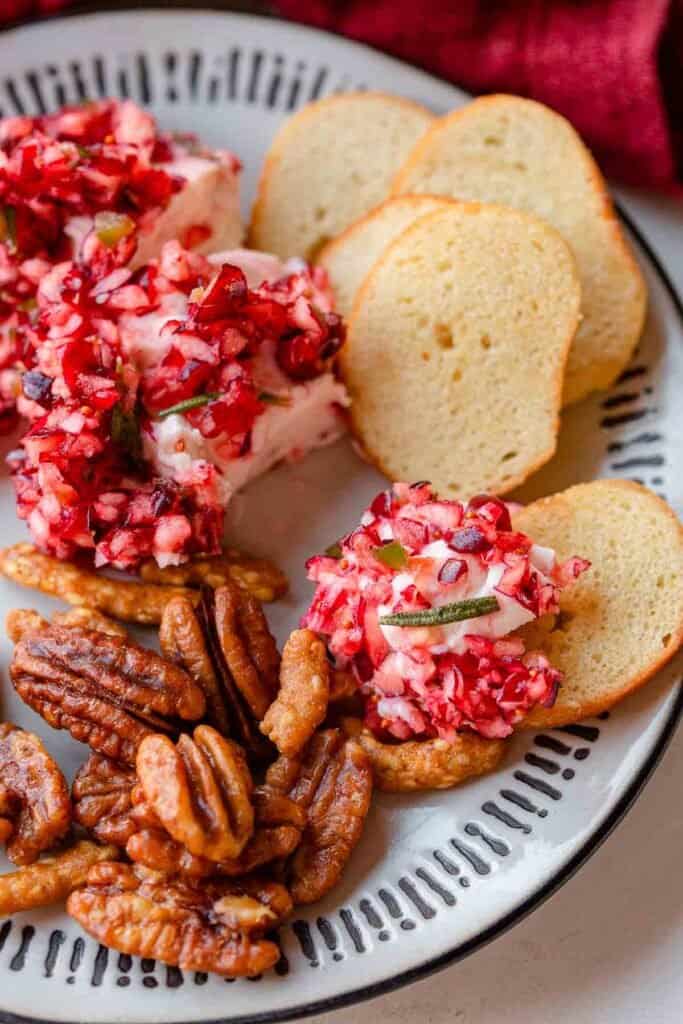 cranberry jalapeno dip in a plate with crackers.