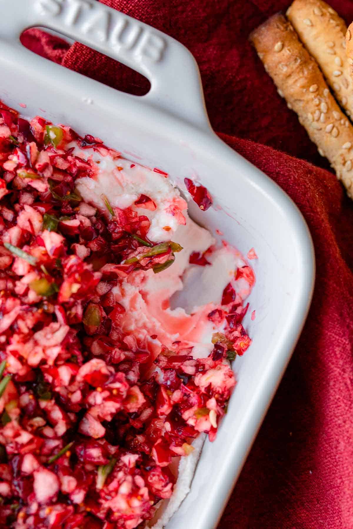 Cranberry jalapeno cream cheese dip in a white casserole dish.