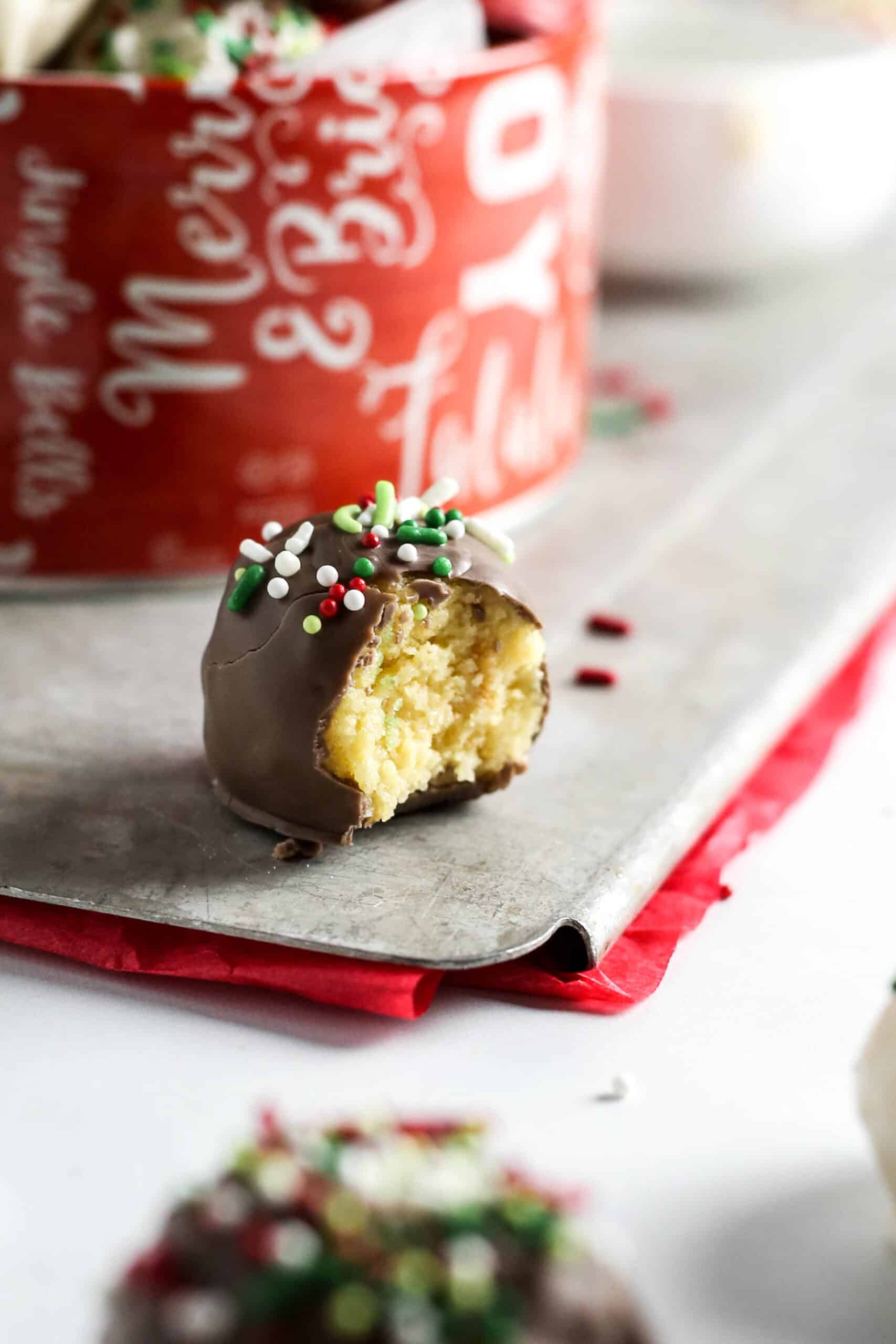 Christmas chocolate and vanilla cake pops without a stick on table with bite taken out.