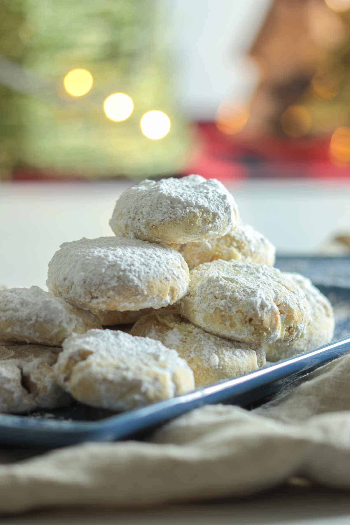 Kourabiedes cookies stacked on blue plate.