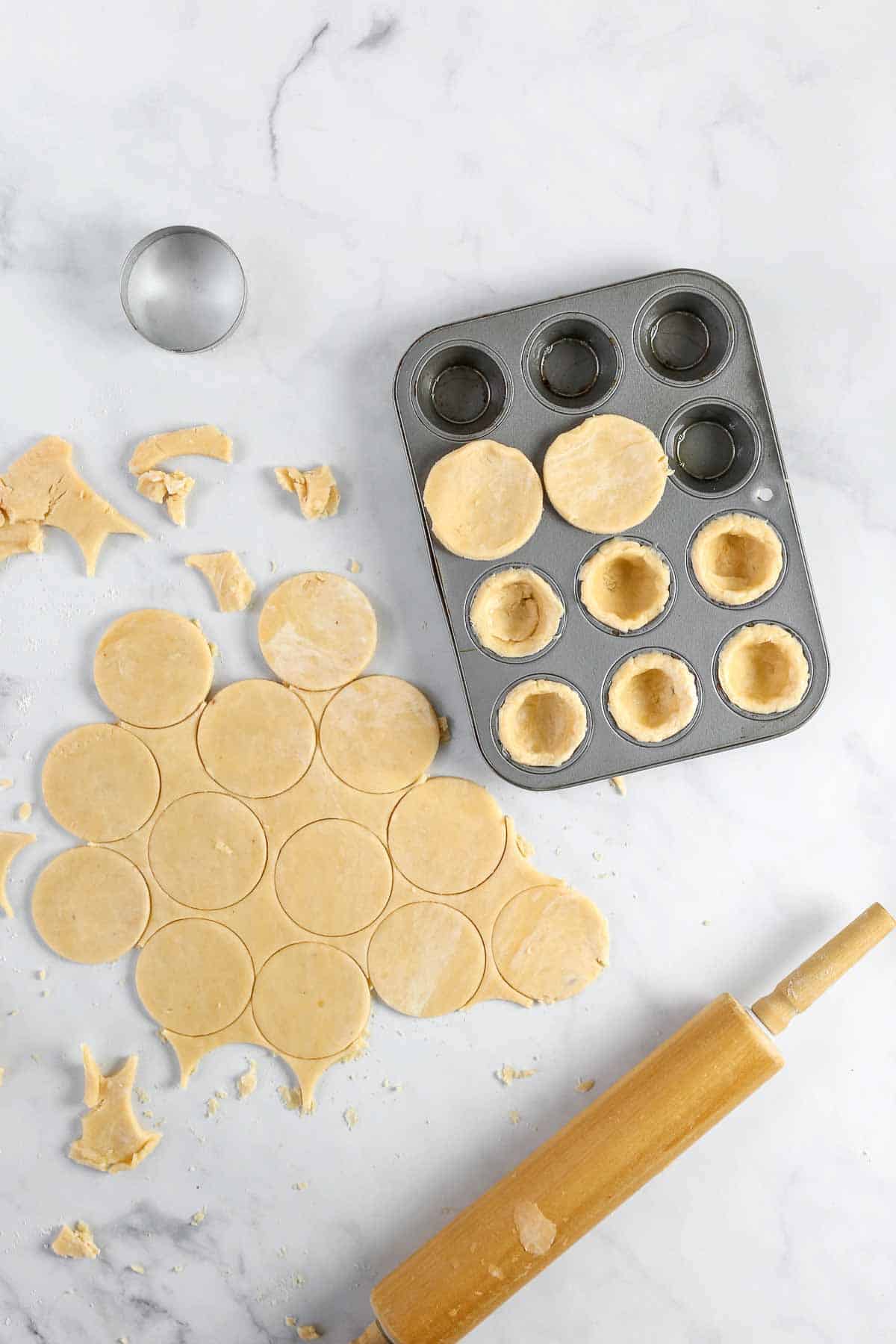 Pressing cream cheese crust into mini muffin tin for nut cups.