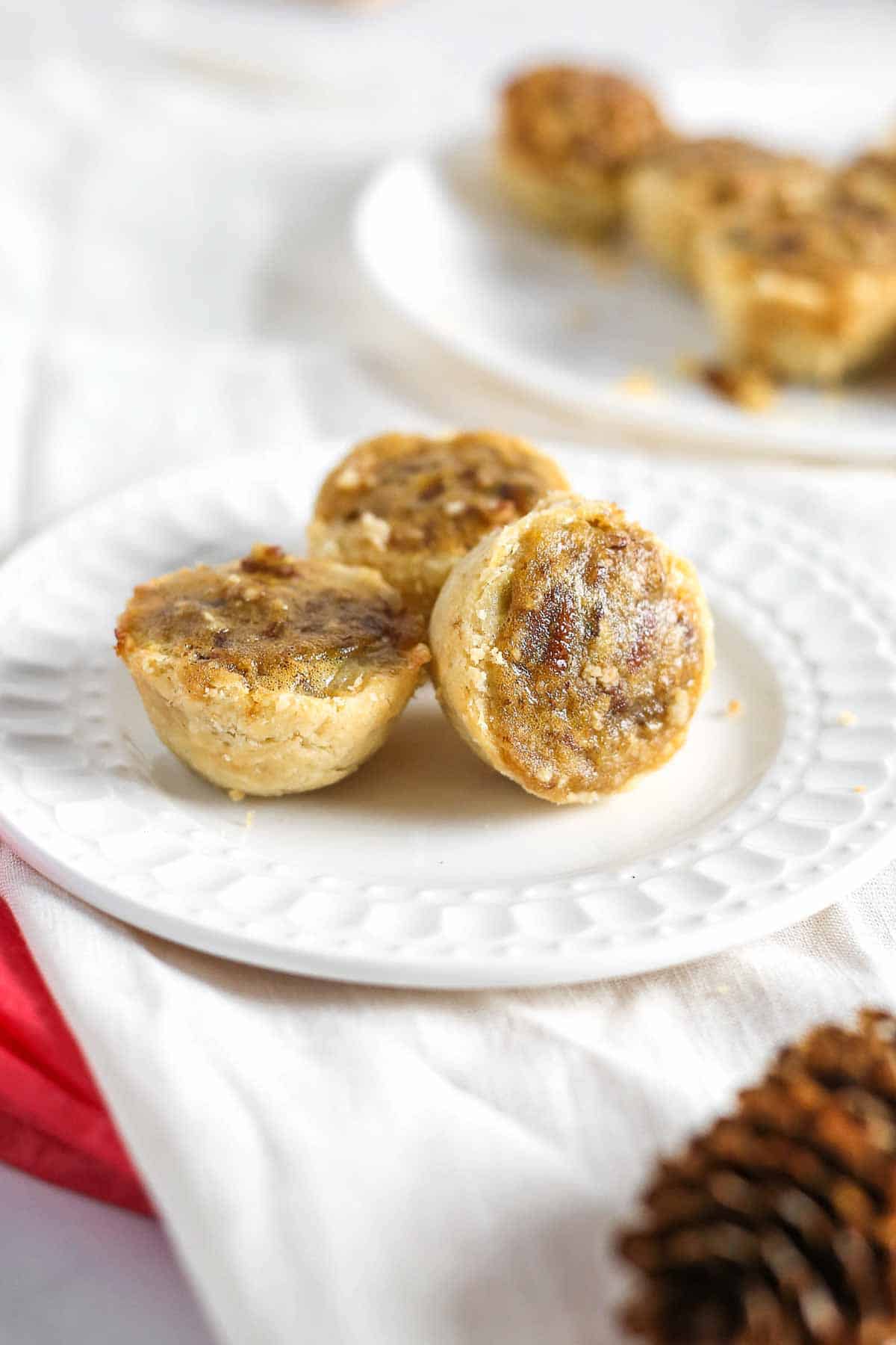 Pecan tassie nut cups on plate.