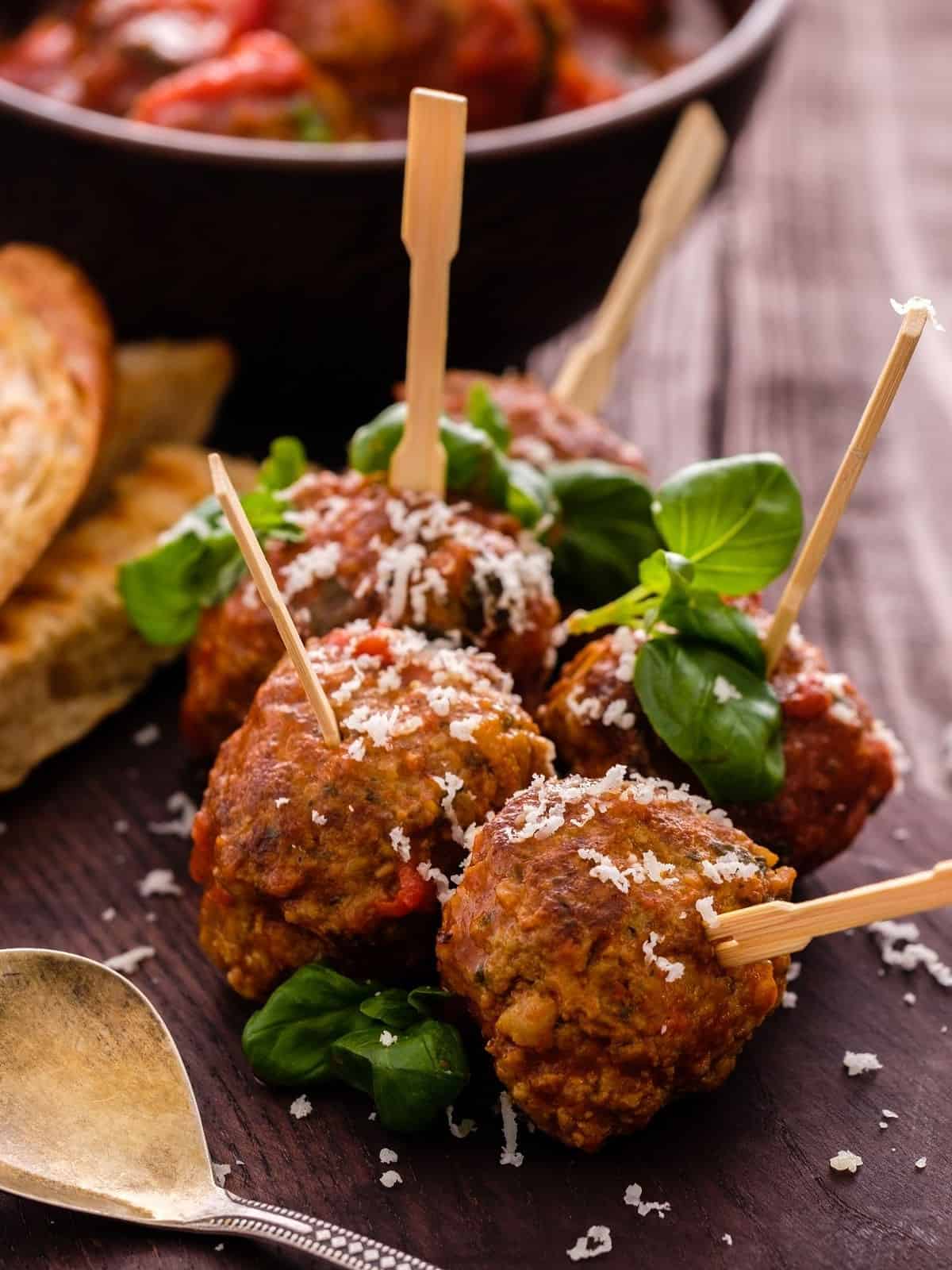 Meatballs on skewers on a plate with sauce.