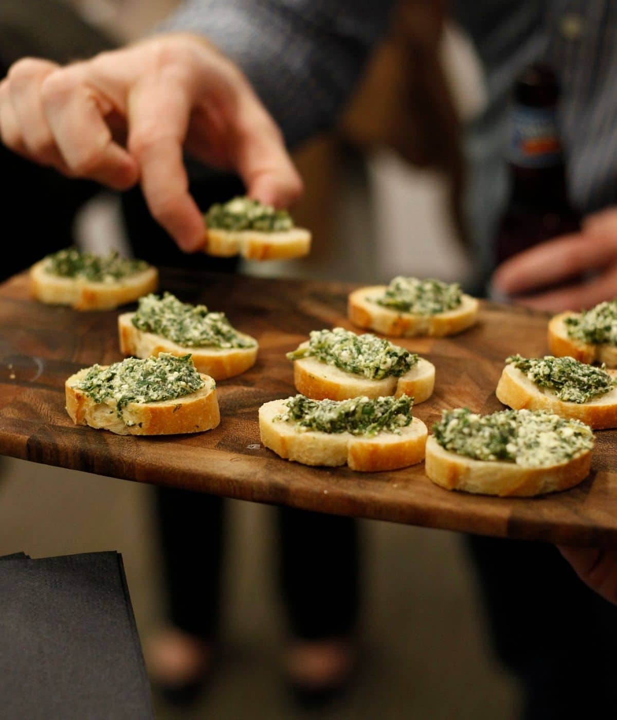 Crostini appetizer being served at a party.