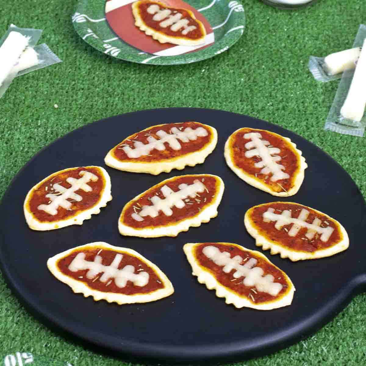 Football pizzas using crescent dough on board.