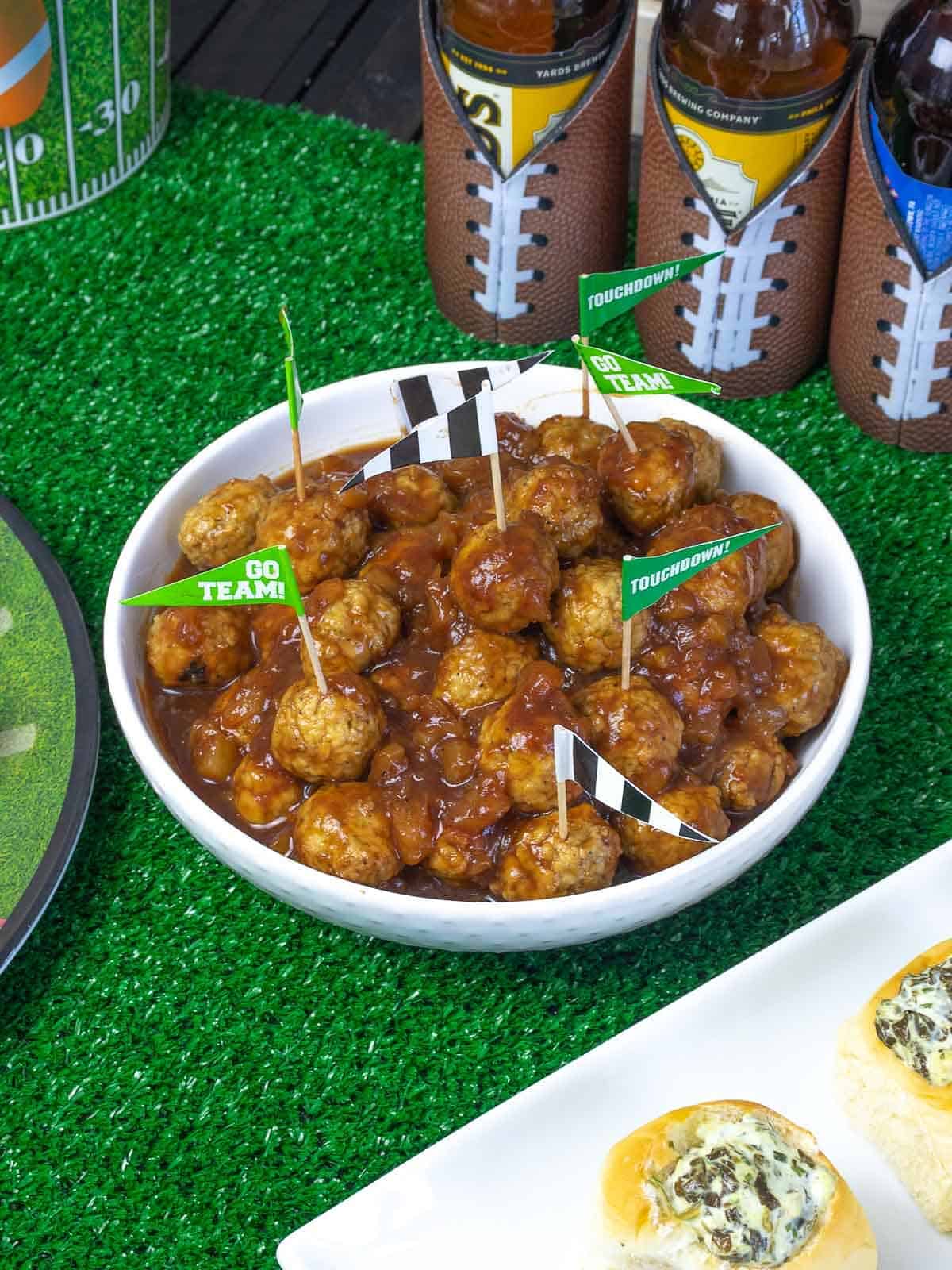 Super Bowl meatball appetizer in a bowl with football toothpick flags.