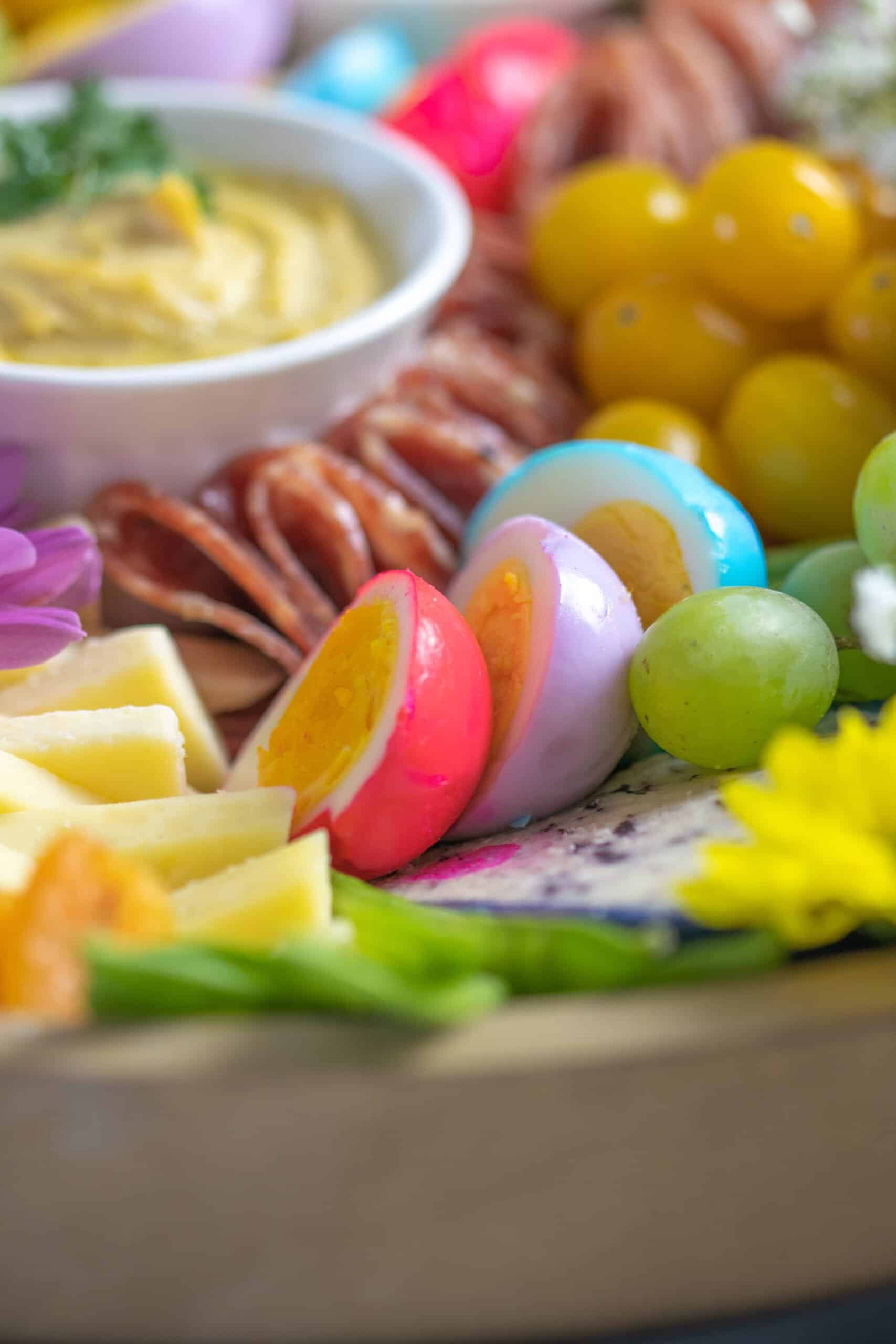 Easter charcuterie board with colored eggs.