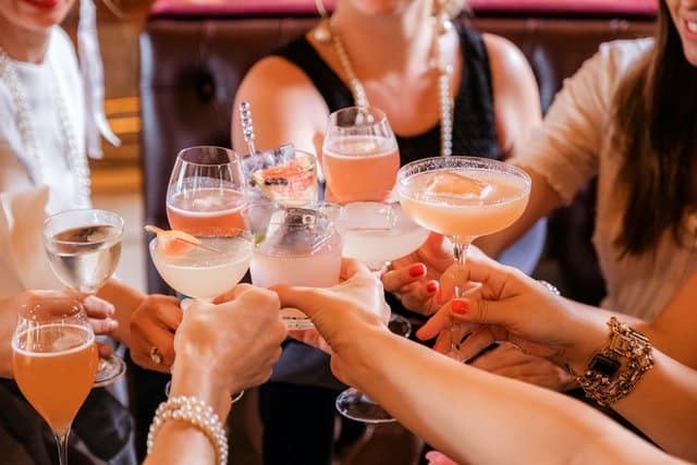 Group of women holding a variety of cocktails.