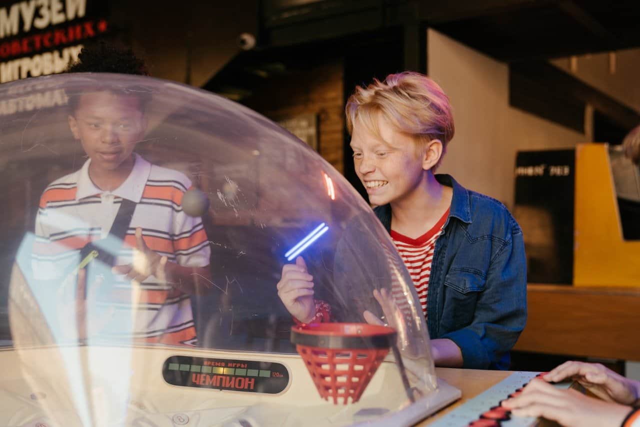 Two boys playing an arcade game.