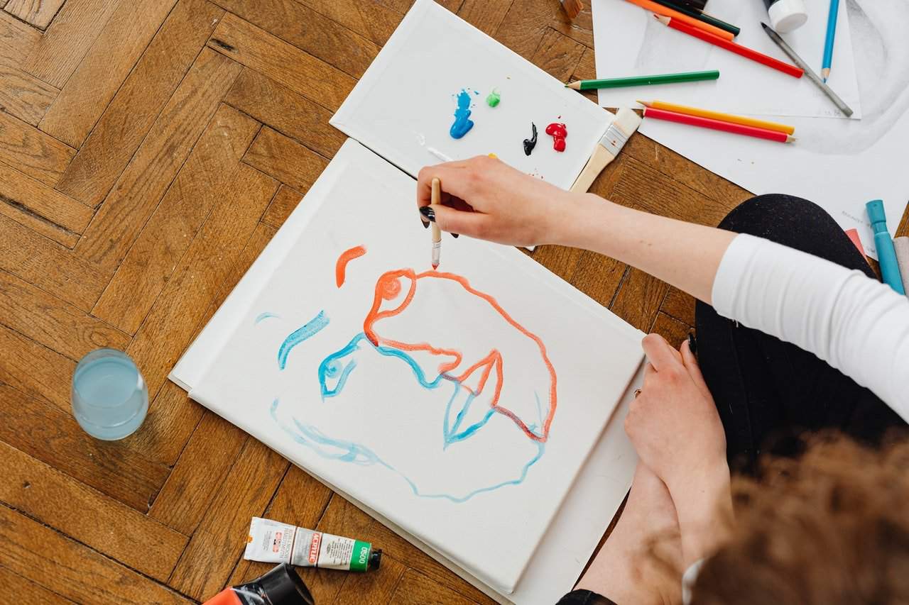 Person painting while sitting on the floor.