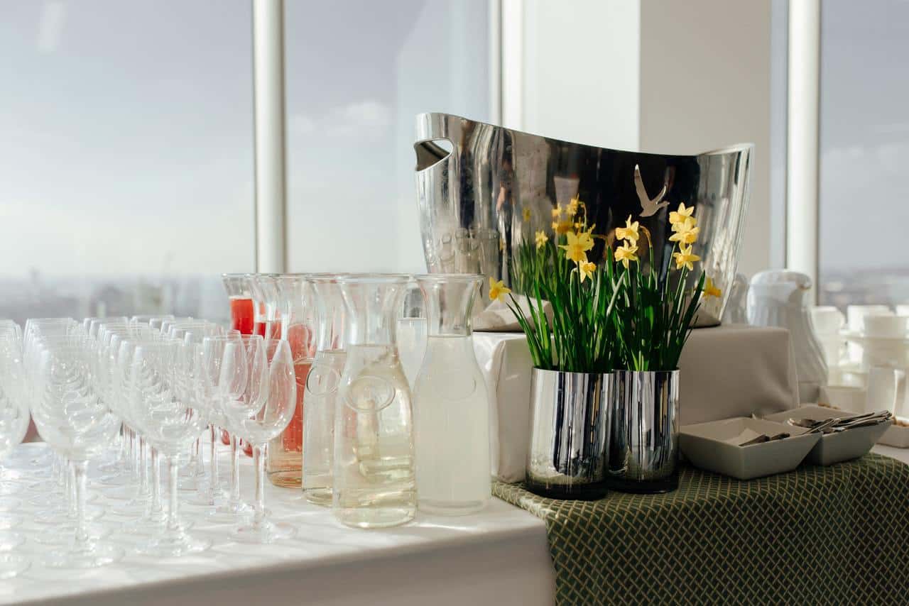 Buffet table with glassware and flowers.