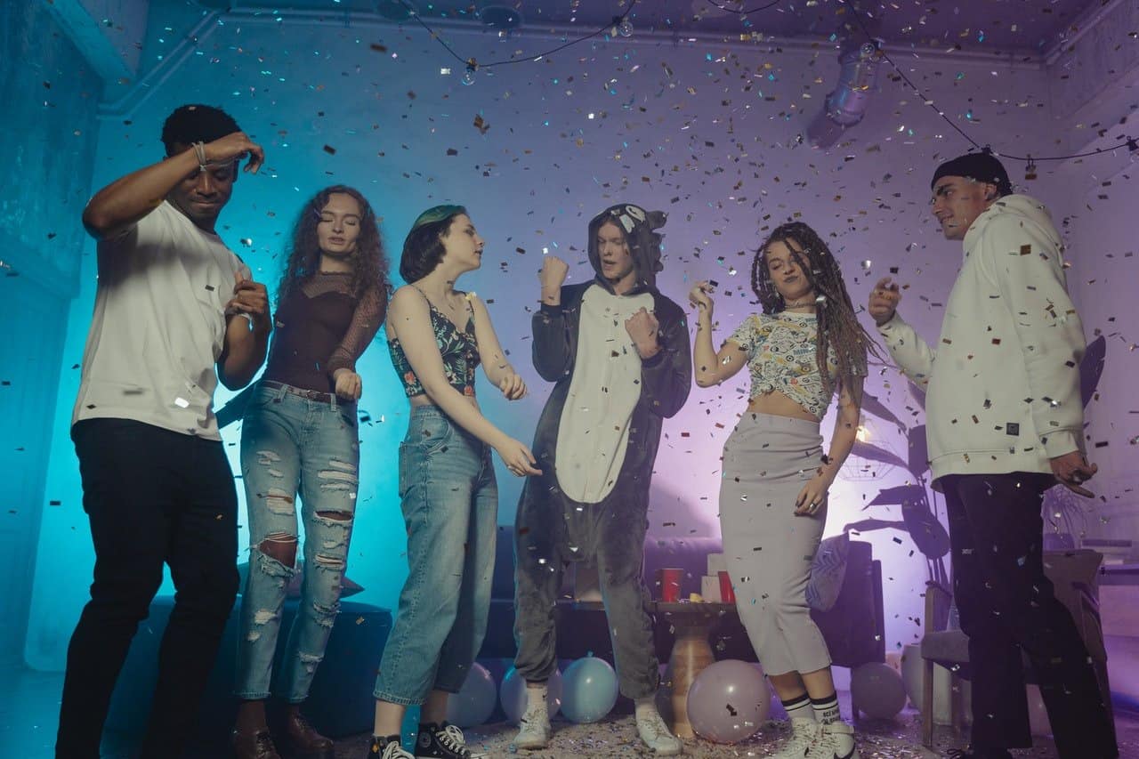 Group of friends dancing together at a house party.