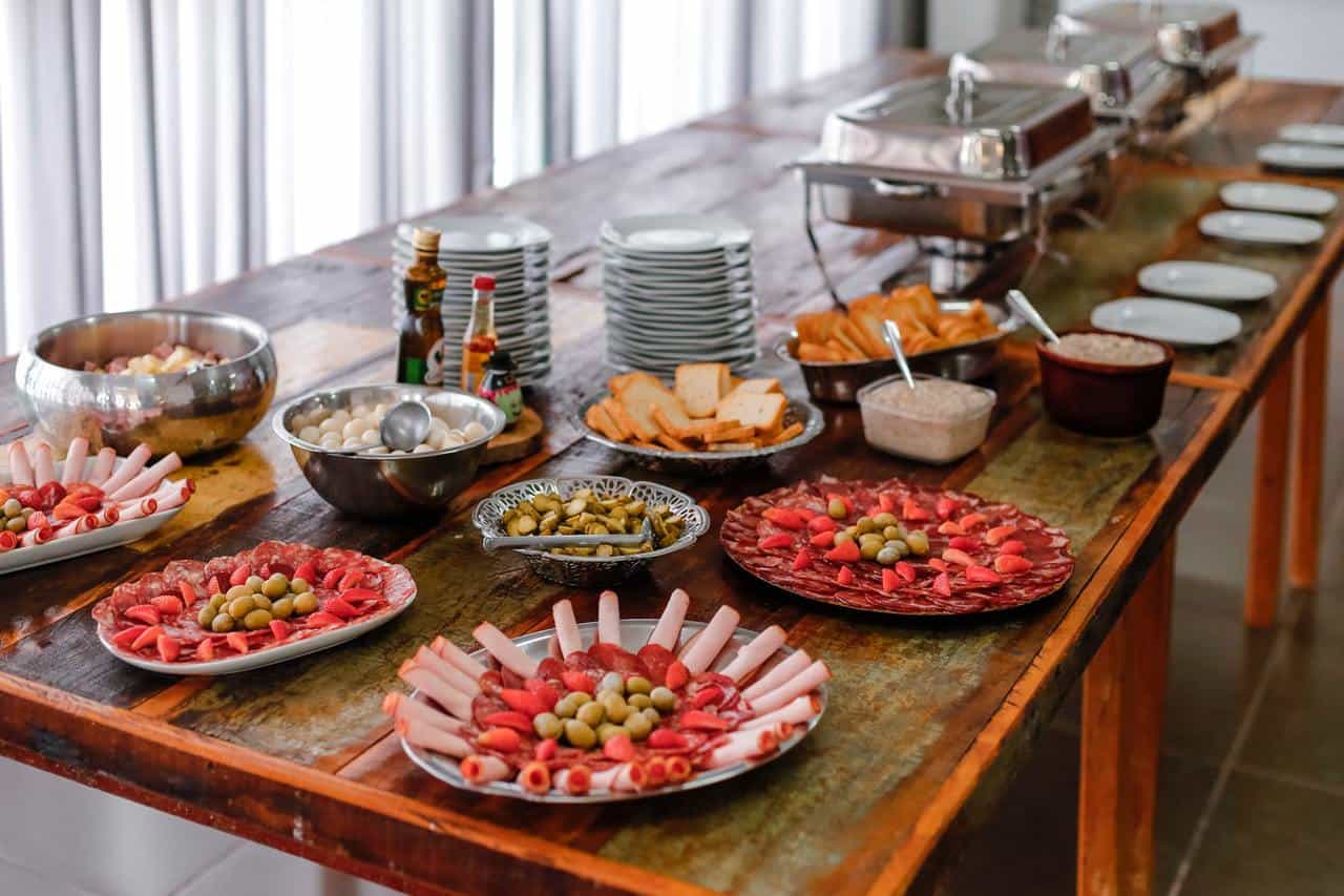 Assorted food on brown wooden buffet table.