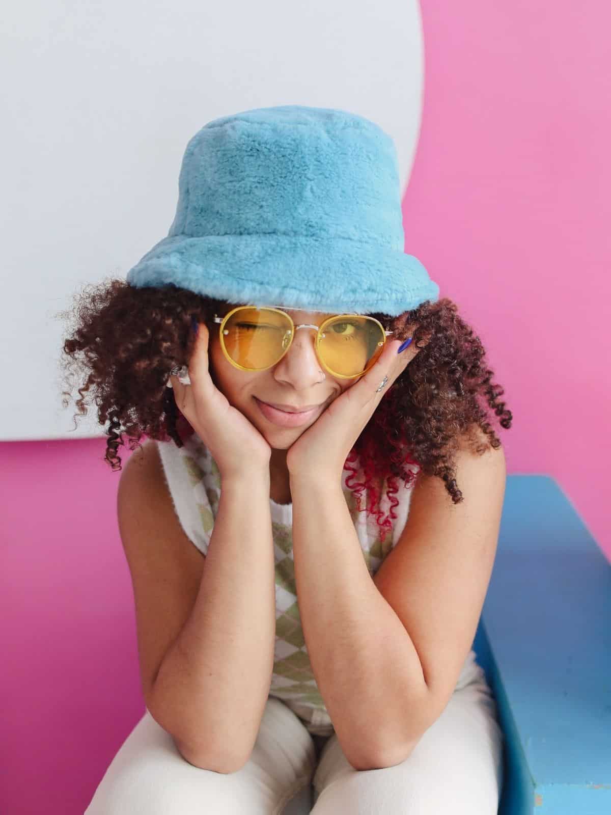 Woman wearing kangol hat with glasses.