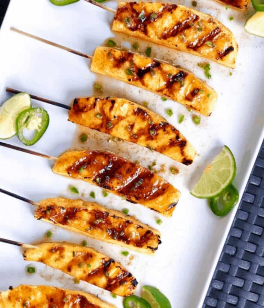 Grilled pineapple skewers on plate.