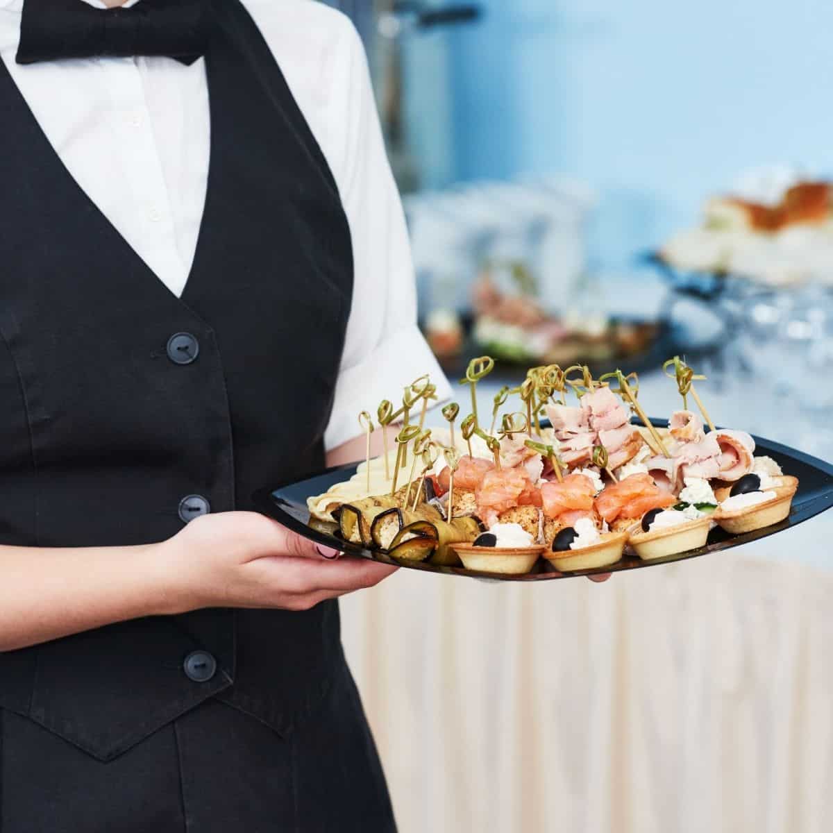 Caterer serving appetizers at a party.