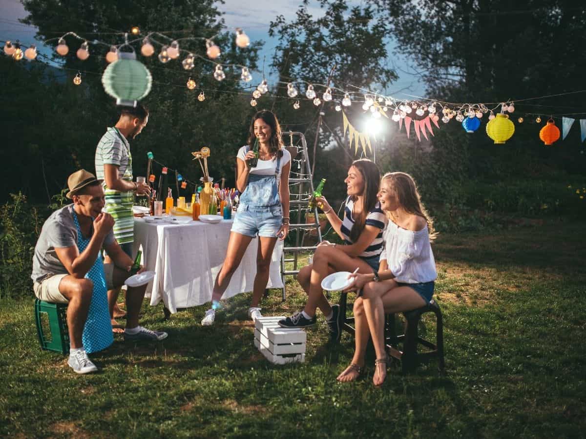 Friends having fun at a housewarming party outside in backyard.