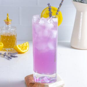 Lavender lemonade drink with lemon wedge.