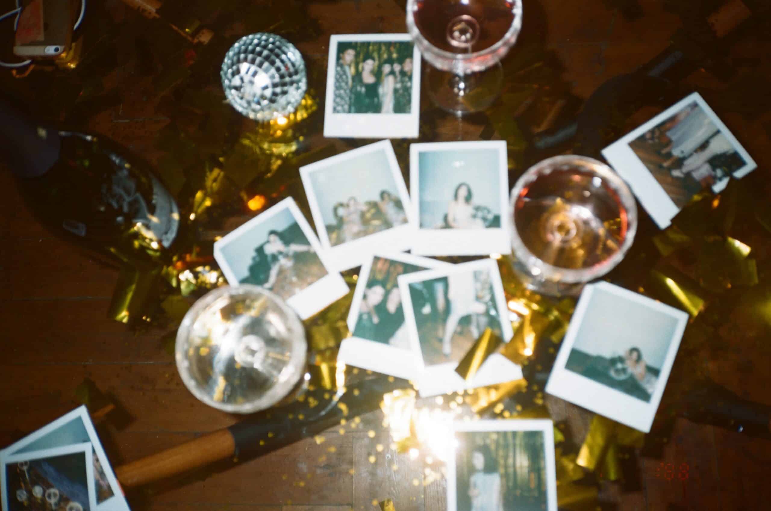 A pile of polaroid pictures with champagne glasses for great housewarming party ideas.