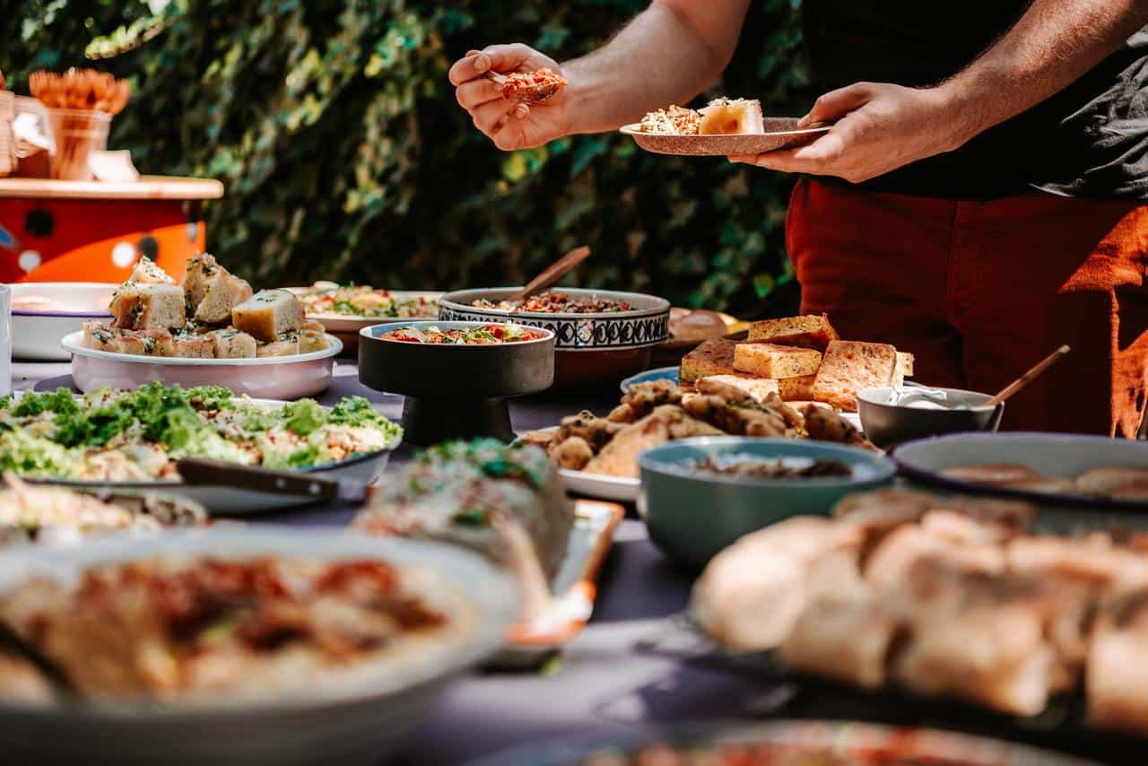 Man filling his plate with food from buffet table.