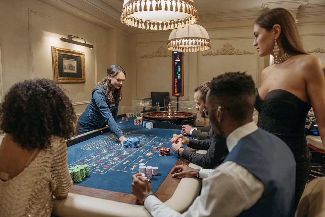 A group of people betting on a roulette table.