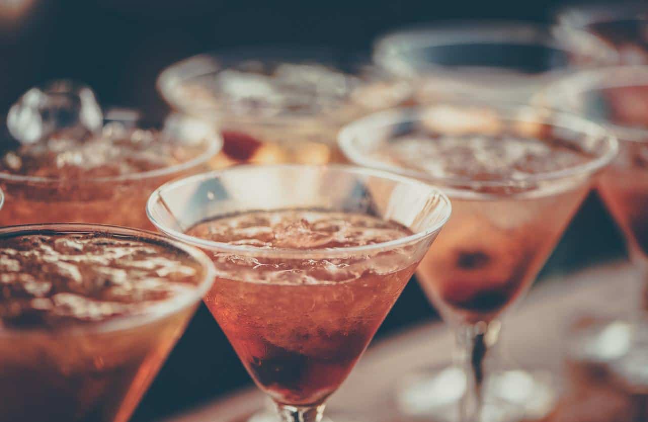 Pink cocktails lined up in a shallow photo.