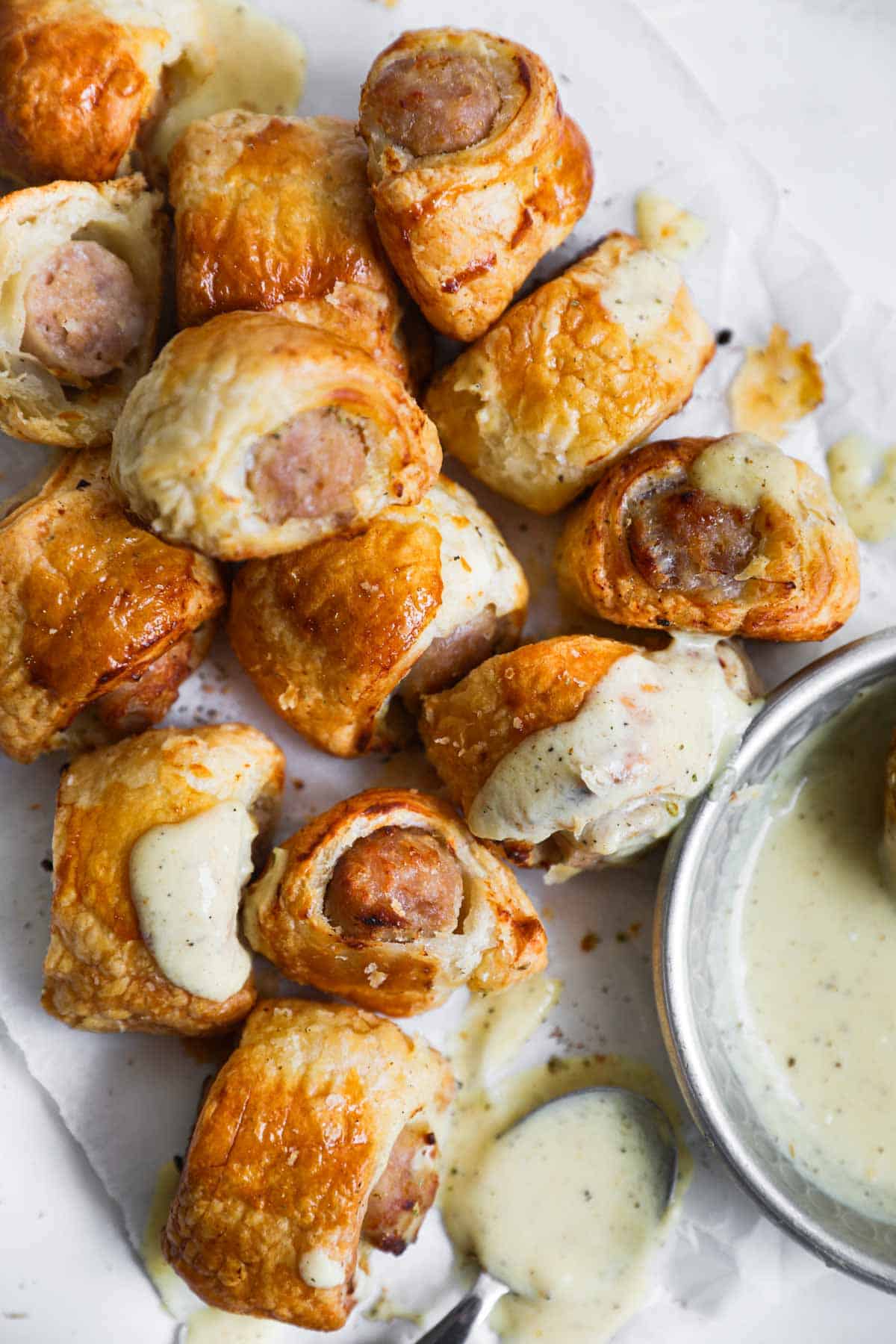 Pigs in a blanket appetizer in a bowl with sauce.