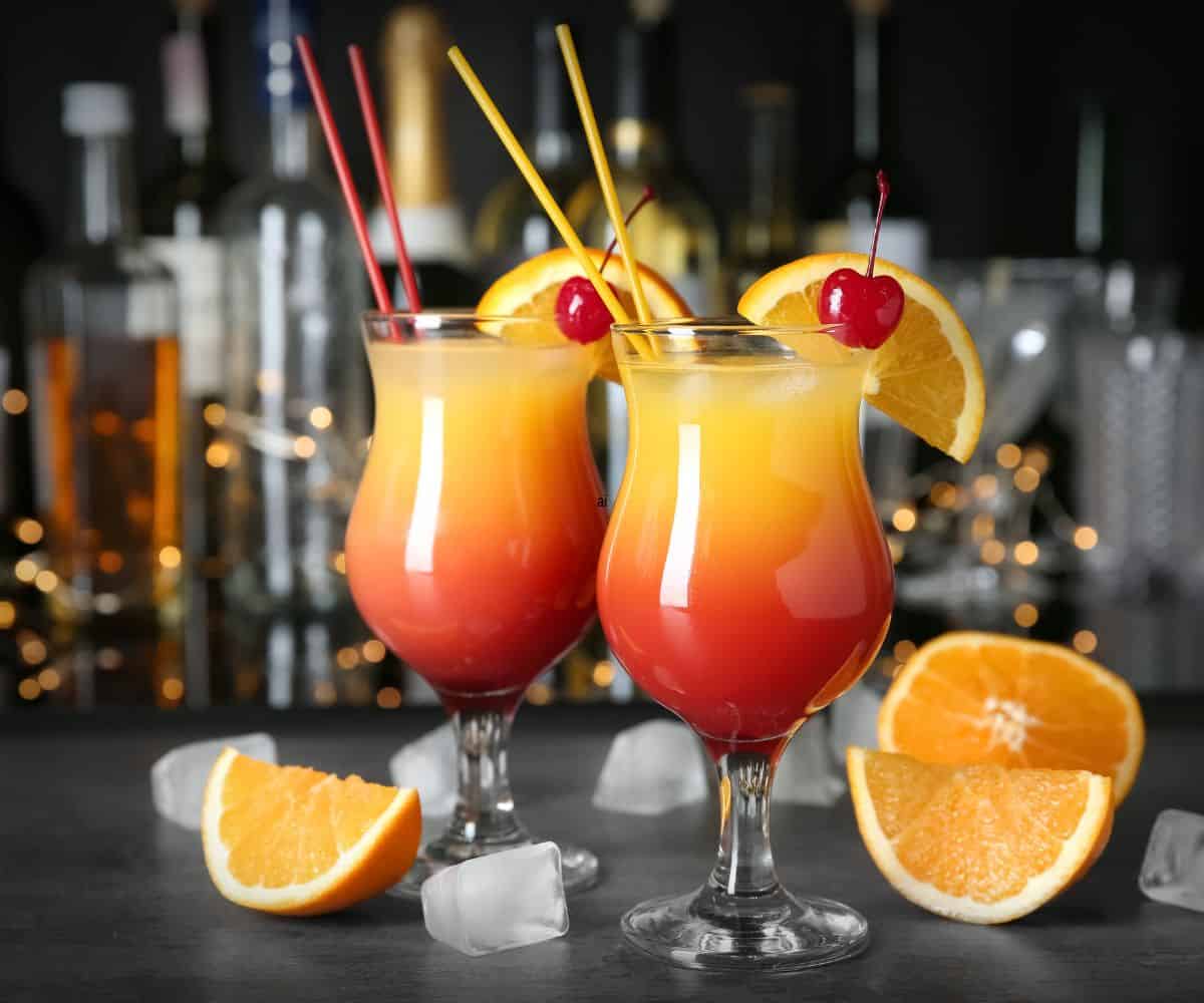 Sex on the beach fruity cocktail with cherry orange and straw.