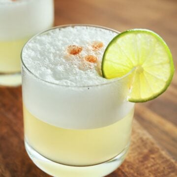 Pisco sour cocktail with lime slice.