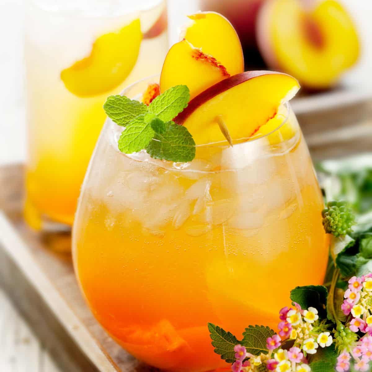 Peach schnapps cocktail with peach and basil garnish.