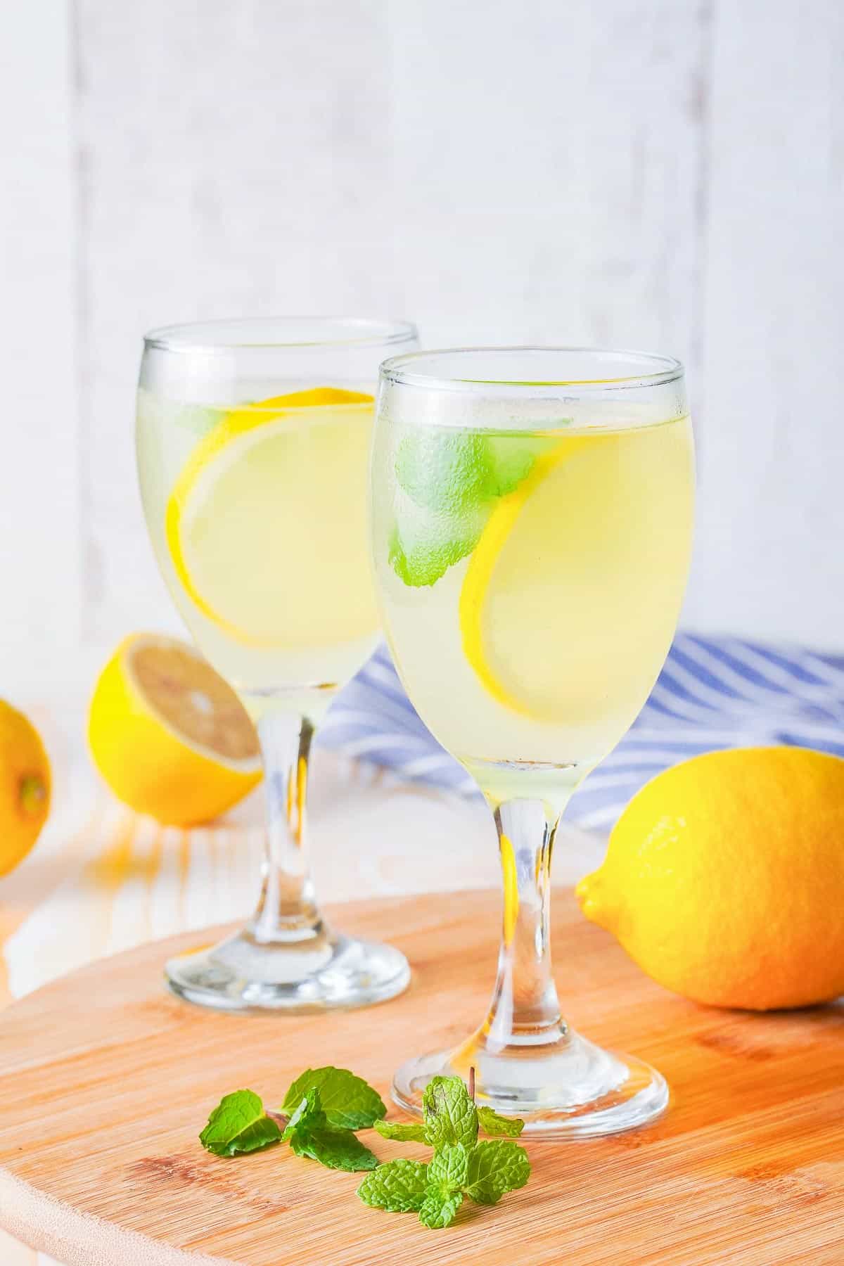 Limoncello spritz in a glass with lemon and mint leaves.