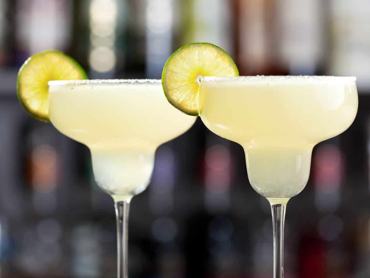 A margarita glass with margarita and lime wheel on rim.