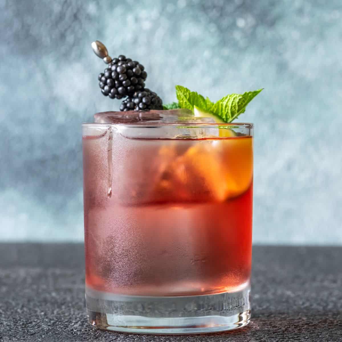 Summer whiskey smash cocktail with berries and mint leaf.