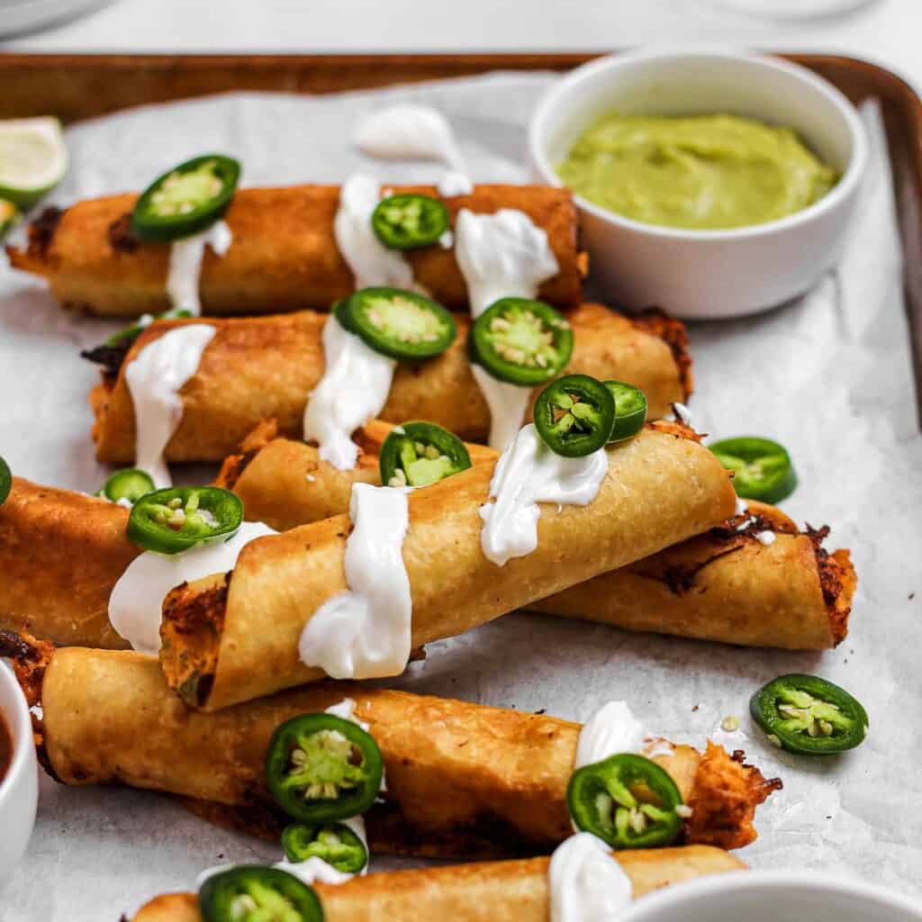 Chicken flautas with sour cream and jalapenos.