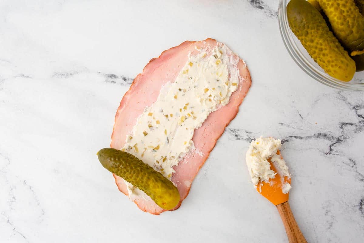 Ham spread with cream cheese and pickle in the center.