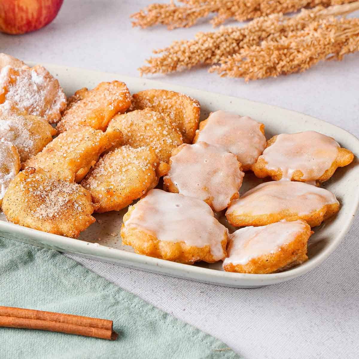 Apple pie fritters on plate with spices and glaze.