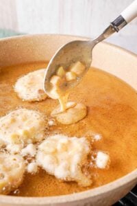 Putting batter mixture into the oil.