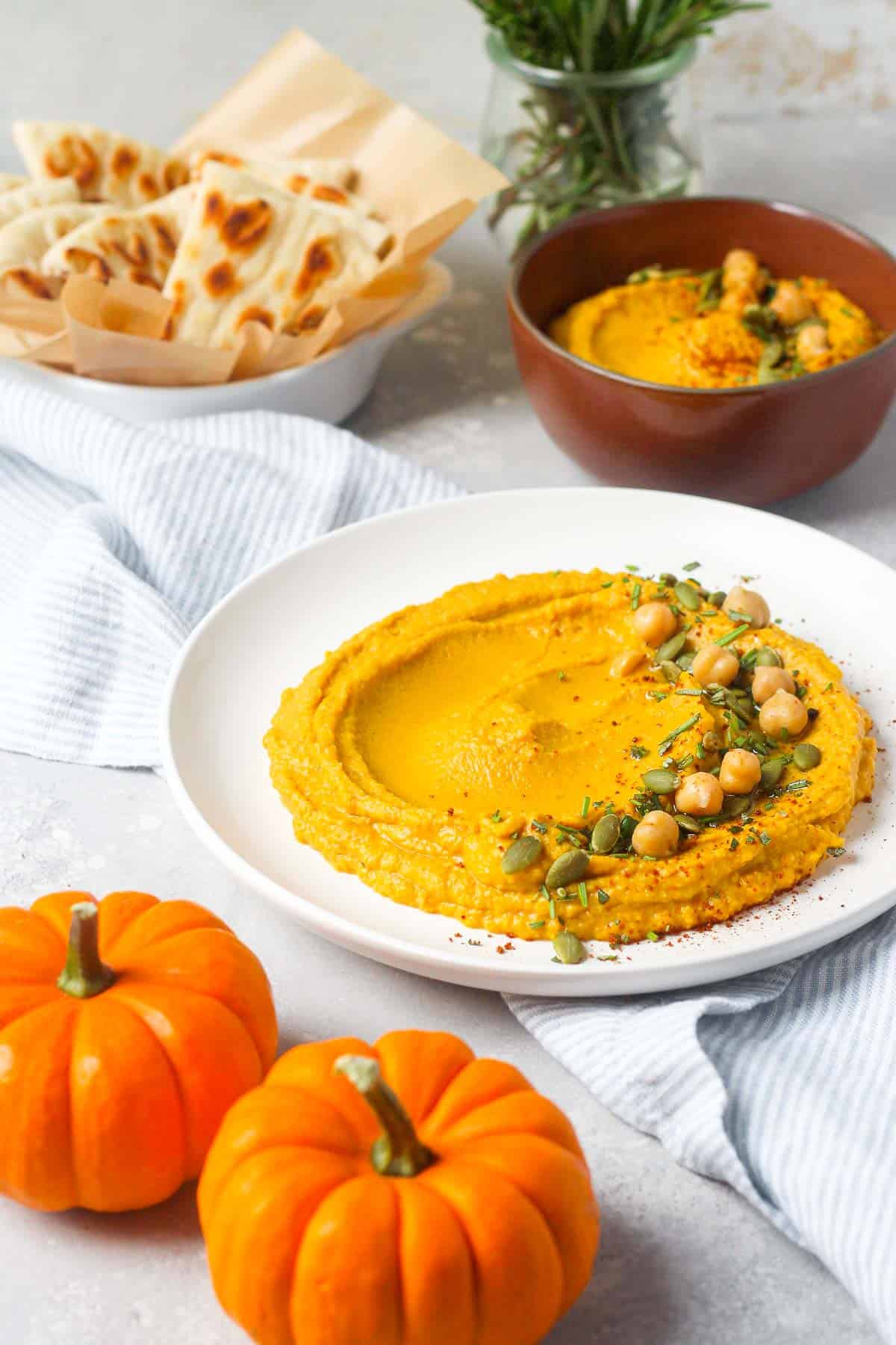 Pumpkin spice hummus on table with pumpkins.