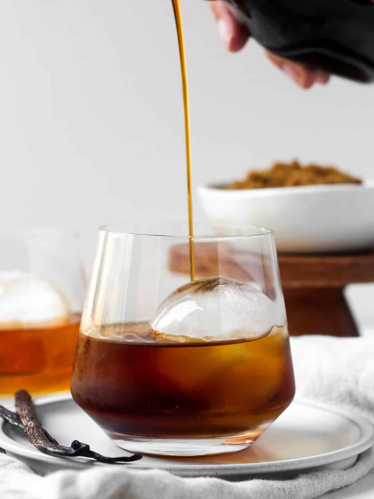 Pouring syrup into a cocktail with ice.