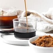 Brown sugar simple syrup being poured into glass.