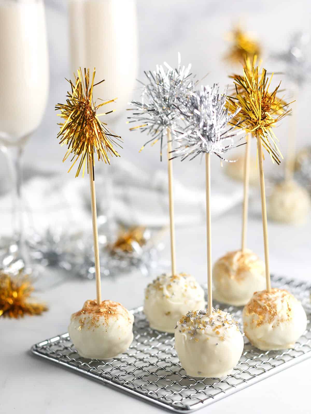 Cake balls on rack with gold and silver tassles.