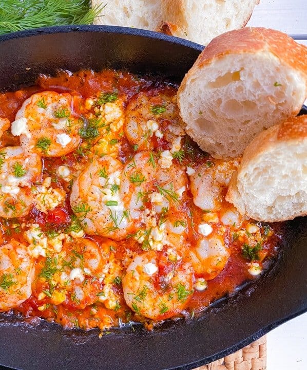 Shrimp saganaki appetizer in cast iron dish.