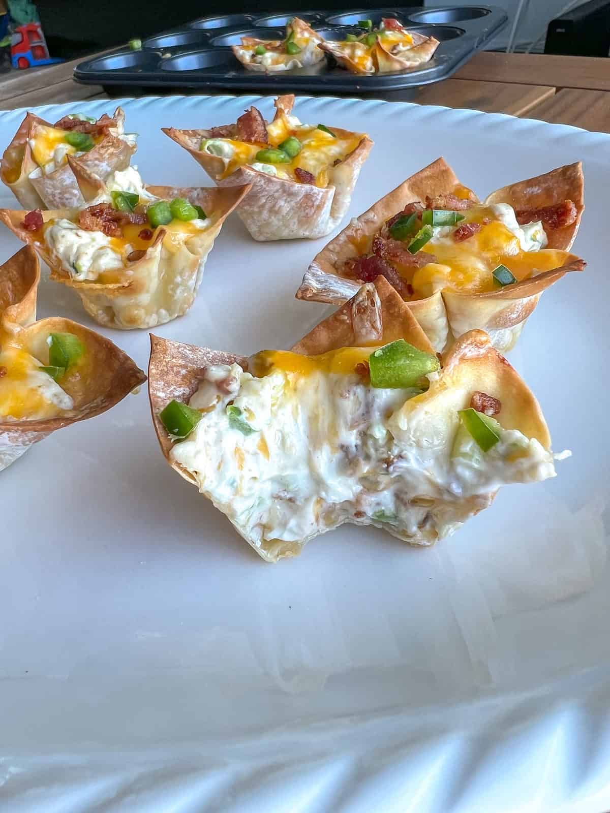 Jalapeno popper filled wontons with a bite taken out.